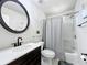 Bright bathroom features a decorative round mirror, modern fixtures, and a shower/tub combo at 7108 Sheffield Dr, Lakeland, FL 33810