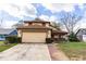 Two-story home with an attached garage, lush landscaping, and a welcoming front entrance at 7440 Windsome Ct, Orlando, FL 32810