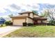 Two-story home featuring an attached two-car garage and a well-maintained front lawn at 7440 Windsome Ct, Orlando, FL 32810