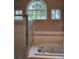 Bathroom featuring a tub, shower, and three windows for natural light at 7741 Bardmoor Hill Cir, Orlando, FL 32835