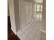 A hallway with tile flooring and a closet, leading to a bright, open area at 7741 Bardmoor Hill Cir, Orlando, FL 32835