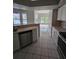 Bright kitchen with stainless steel appliances, tile floors and views into the living room at 7741 Bardmoor Hill Cir, Orlando, FL 32835