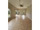 Living room with tiled floor, neutral walls, ceiling fan and large windows to the yard at 7741 Bardmoor Hill Cir, Orlando, FL 32835