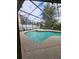 Private screened-in pool area with a hot tub and lush landscaping at 7741 Bardmoor Hill Cir, Orlando, FL 32835