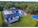 Aerial shot of a modern home with a pool, outdoor seating, lush landscaping, and a sport court at 900 W Plant St, Winter Garden, FL 34787
