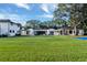 Sprawling backyard featuring a home exterior, pool, and lush green lawn with mature trees at 900 W Plant St, Winter Garden, FL 34787