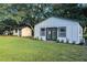 Charming backyard features a shed with black trim and a swing set under mature shade trees at 900 W Plant St, Winter Garden, FL 34787