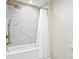 Bright bathroom featuring a tub and shower with white marble tile and gold fixtures at 900 W Plant St, Winter Garden, FL 34787