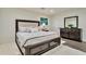 Spacious bedroom with hardwood floors, a queen-sized bed, and a dark wood dresser with mirror at 900 W Plant St, Winter Garden, FL 34787