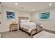Cozy bedroom featuring hardwood floors, a bed with white linens, and natural light from two windows at 900 W Plant St, Winter Garden, FL 34787
