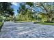 Long paved driveway leading to a gated entrance, lined with manicured landscaping and mature trees at 900 W Plant St, Winter Garden, FL 34787