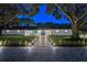 Nighttime view of a single-story home with a landscaped front yard and a stone pathway with lights leading to the front door at 900 W Plant St, Winter Garden, FL 34787