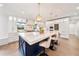 A luxurious kitchen island with marble countertop is surrounded by chairs, and features pendant lighting at 900 W Plant St, Winter Garden, FL 34787