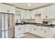 Bright kitchen features white cabinetry, marble countertops, stainless steel appliances, and modern fixtures at 900 W Plant St, Winter Garden, FL 34787