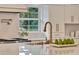Bright kitchen with stainless steel appliances, marble countertops, and a modern sink at 900 W Plant St, Winter Garden, FL 34787
