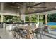 The outdoor kitchen has a granite countertop, stainless steel appliances, and dining space at 900 W Plant St, Winter Garden, FL 34787