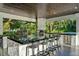 Close up view of the outdoor kitchen with granite countertops, stainless steel appliances, and pizza oven at 900 W Plant St, Winter Garden, FL 34787