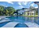 Home exterior featuring backyard pool with built in lounge chairs and patio, surrounded by lush lawn at 900 W Plant St, Winter Garden, FL 34787