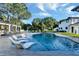 Home exterior featuring a backyard pool, lounge areas, and lush lawn with mature trees at 900 W Plant St, Winter Garden, FL 34787