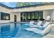 Backyard pool featuring in-pool lounge chairs and a modern home exterior with large sliding glass doors at 900 W Plant St, Winter Garden, FL 34787