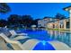 Nighttime view of a modern pool and outdoor seating area with lights and exterior home architecture at 900 W Plant St, Winter Garden, FL 34787