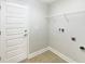 Clean laundry room showcasing a white door, tile flooring, and wire shelving for organized storage at 947 Cumberland Dr, Kissimmee, FL 34759