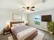 Cozy primary bedroom with ceiling fan, window view, and stylish wooden furniture at 947 Cumberland Dr, Kissimmee, FL 34759