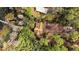 Aerial view of a secluded brown roof house surrounded by lush greenery and mature trees with water access at 10433 Trout Rd, Orlando, FL 32836