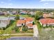 Beautiful home with a red tile roof, mature trees, and lush green lawn overlooking a tranquil pond at 10616 Emerald Chase Dr, Orlando, FL 32836