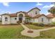 Stunning two-story home featuring a terracotta tile roof, manicured lawn, and lush landscaping at 10616 Emerald Chase Dr, Orlando, FL 32836