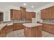Spacious kitchen featuring wood cabinetry, a tiled island, and modern appliances at 10616 Emerald Chase Dr, Orlando, FL 32836