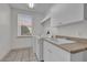 Laundry room with a utility sink, countertop, storage cabinets, and a window at 10616 Emerald Chase Dr, Orlando, FL 32836