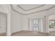 Bright, expansive living room with columns, carpet, neutral walls, and double doors leading to the pool area at 10616 Emerald Chase Dr, Orlando, FL 32836