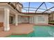 A screened-in pool and spa are surrounded by a spacious patio and overlook a well-maintained lawn at 10616 Emerald Chase Dr, Orlando, FL 32836