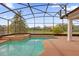 The screened-in pool and hot tub offer scenic views of the backyard and surrounding homes at 10616 Emerald Chase Dr, Orlando, FL 32836