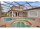 A screened-in pool and spa are surrounded by a spacious patio and overlook a well-maintained lawn at 10616 Emerald Chase Dr, Orlando, FL 32836