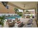 Inviting backyard featuring a pool, cozy seating, fire pit, lush landscaping, and privacy fence at 1077 Fountain Coin Loop, Orlando, FL 32828