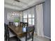 Elegant dining room with modern chandelier, large windows with custom blinds, and seating for six at 1077 Fountain Coin Loop, Orlando, FL 32828