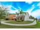 Expansive lawn and mature landscaping surround this beautiful home's brick driveway and architectural details at 1077 Fountain Coin Loop, Orlando, FL 32828