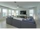 Spacious living room with a large sectional sofa, big windows, and a ceiling fan at 1077 Fountain Coin Loop, Orlando, FL 32828