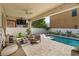 Resort-style covered outdoor living space with pool, lounge seating, and fire feature at 1077 Fountain Coin Loop, Orlando, FL 32828
