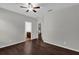 Comfortable bedroom with wood floors; doorway to ensuite bathroom at 127 Blackstone Creek Rd, Groveland, FL 34736