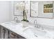 Close-up of double sink vanity with marble countertop and modern chrome faucets at 1300 Montego Ln, Orlando, FL 32807