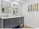 Bathroom vanity with double sinks, modern hardware, and an artistic mirror at 1300 Montego Ln, Orlando, FL 32807