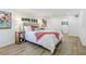 Bright bedroom features a plush headboard, stylish wood nightstand with see-through doors, and light wood flooring at 1300 Montego Ln, Orlando, FL 32807