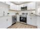 Well-equipped kitchen with stainless steel appliances, ample counter space, and white cabinetry at 1300 Montego Ln, Orlando, FL 32807