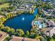 Expansive aerial view of a large community lake with a lighted fountain feature and lakeside pool and lounge at 1357 Venezia Ct # 402, Davenport, FL 33896