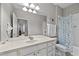 Bright bathroom features a large mirror, white vanity and a blue patterned shower curtain at 1357 Venezia Ct # 402, Davenport, FL 33896