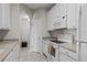 Clean kitchen with white appliances, cabinets, and tiled flooring and view to an open hallway at 1357 Venezia Ct # 402, Davenport, FL 33896