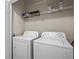 Laundry room features a white washer and dryer with shelf storage at 1357 Venezia Ct # 402, Davenport, FL 33896